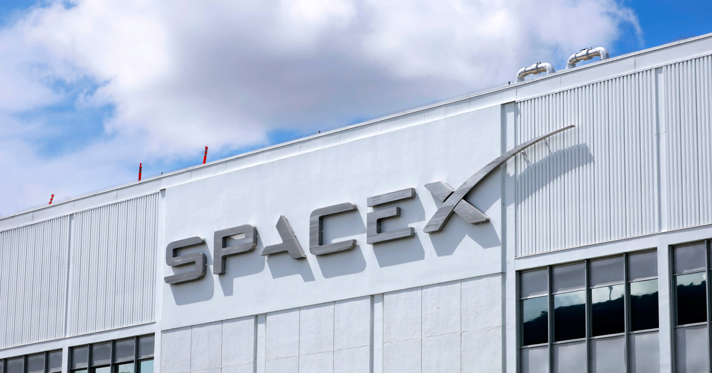 Илон Маск и логотип SpaceX на фоне серверной инфраструктуры